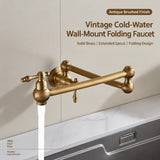 A wall-mounted brushed brass folding faucet with an extended spout, shown from the side above a sink against a plain background.