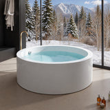 A round white bathtub filled with water, set against a snowy mountain backdrop with trees.