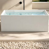 A minimalist bathtub placed on a stone surface with water inside and a modern, clean backdrop.