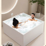 A modern bathtub with two people relaxing in a bubbly setting.