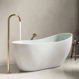 A modern bathtub with a sleek design and a gold faucet in a stylish bathroom setting.