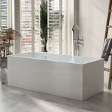 A modern white bathtub in a bright room with a decorative plant and stylish fixtures