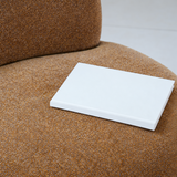 Close-up of a rust-brown chenille swivel barrel chair seat with a white book resting on it