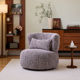 Mottled lilac swivel barrel chair with lumbar cushion facing a wood side table in a warm living room