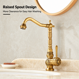 Brass vintage kitchen faucet with raised spout, floral engravings, and side lever, displayed on a light marble countertop.