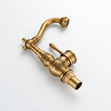 Brass vintage kitchen faucet with carved floral body and threaded base, shown isolated on a white background.