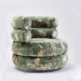 Armless green and cream marbled barrel chair with stacked round cushions on a white backdrop