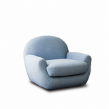 Light blue upholstered swivel barrel chair shown at an angle on a white studio background with a soft floor shadow