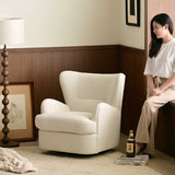 Cream textured swivel barrel chair in a wood-panelled corner with a woman sitting nearby, bead floor lamp and framed art