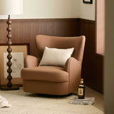 Camel swivel barrel chair with woven cushion in a wood-panelled room, beaded floor lamp nearby.