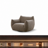 Taupe textured bouclé swivel barrel chair with cat-ear backrest on a white studio background above a blurred dark facade