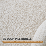 Close-up of cream loop-pile bouclé upholstery texture with a curved edge and English fabric text