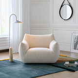 Off-white curly fleece swivel chair on a blue rug in a white paneled room