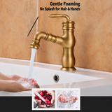 Brushed antique brass faucet pouring an aerated stream over hands in a white sink