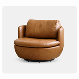 Caramel leather-look swivel barrel chair with plush cushion on a light gray studio backdrop
