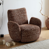 Brown textured chenille swivel barrel chair on a wood floor beside wrapped boxes and a dried branch in a vase