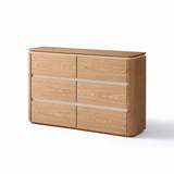Light oak sideboard with six drawers and a rounded right corner, angled view on white background