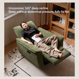 Olive green upholstered recliner chair with a resting man in a warm living room