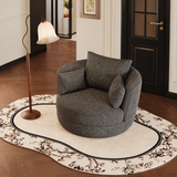 Charcoal grey swivel barrel chair with two cushions on a floral rug