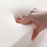 Hand pressing the cream upholstery of a swivel barrel chair, showing the padded surface texture