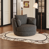Charcoal woven swivel barrel chair with three cushions on a floral rug beside a curved floor lamp
