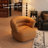 Ochre chenille swivel barrel chair on a wood floor beside a black leather sofa and floral rug, with English text overlay