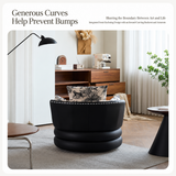 Black leather swivel barrel chair with toile cushion seen from behind in a wood-floored living room
