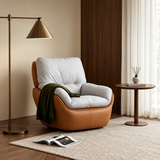 Tan swivel barrel chair with gray cushions and green throw beside brass floor lamp in warm living room