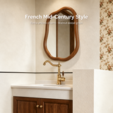 Vintage kitchen faucet with wood-grain handle and curved spout, set against a floral wallpaper in a bright bathroom.