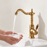 Vintage copper kitchen faucet with wood-grain handle, water flowing into cupped hands above a white sink.