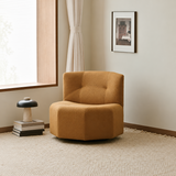 Tan upholstered swivel barrel chair in a warm room beside a window and floor lamp