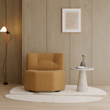 Tan boucle barrel swivel chair in a warm wood-paneled room with a stone side table