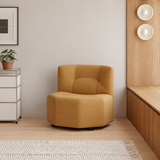 Tan barrel chair with textured upholstery in a warm wood-accented room