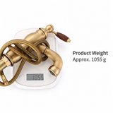 Antique brass kitchen faucet with coiled hose and wood-grain handle resting on a digital scale showing 1055 g
