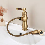 Antique brass kitchen faucet with wood-grain lever handle and pull-out hose resting on a white sink