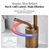 Antique brushed brass faucet featuring a curved handle for hot and cold control, set against a light marble background.