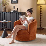 Woman reading in a rust-orange chenille swivel barrel chair by a black sideboard and floor lamp