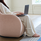 Side view of a blush pink velvet swivel barrel chair with a 15.7"/40cm seat height diagram, woman with laptop seated.