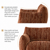 Rust-brown ribbed barrel chair detail: curved cat-ear back and plump rounded seat, white backdrop