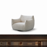 Cream textured swivel barrel chair on white above a dark modern storefront facade